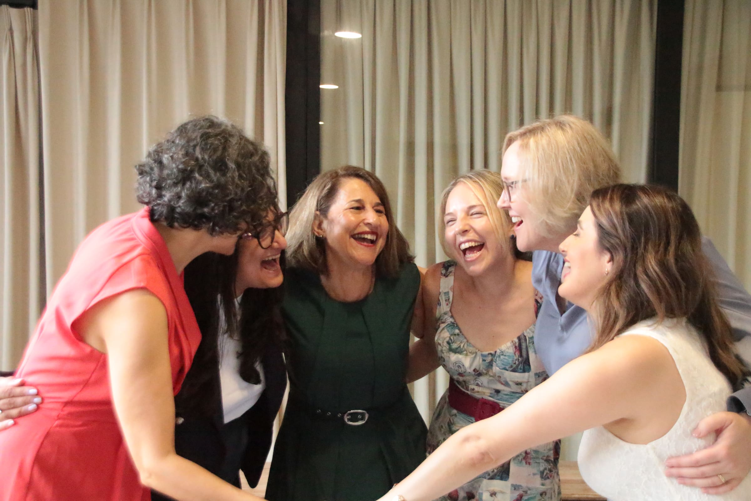 Antonietta laughing closely together with four women clients