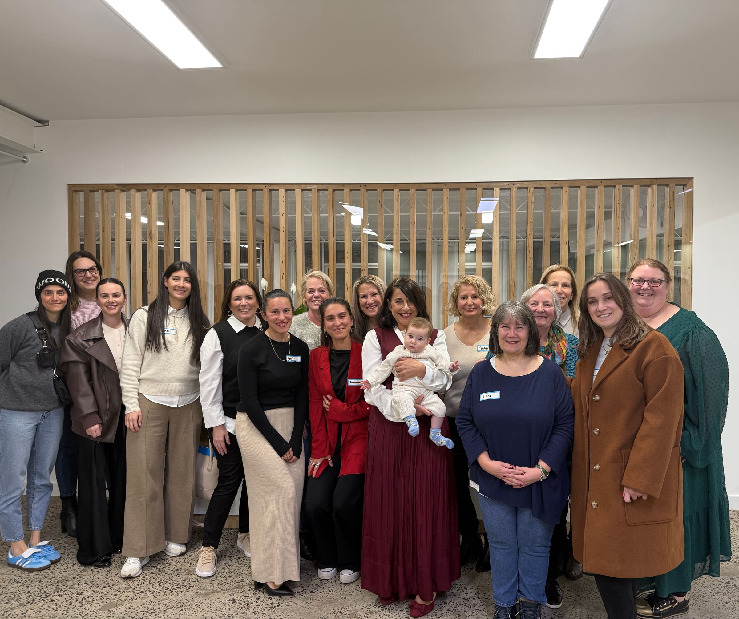 A large group of workshop attendees, including testimonial client Ayke, gathered together with name tags at a Valuing Our Worth event